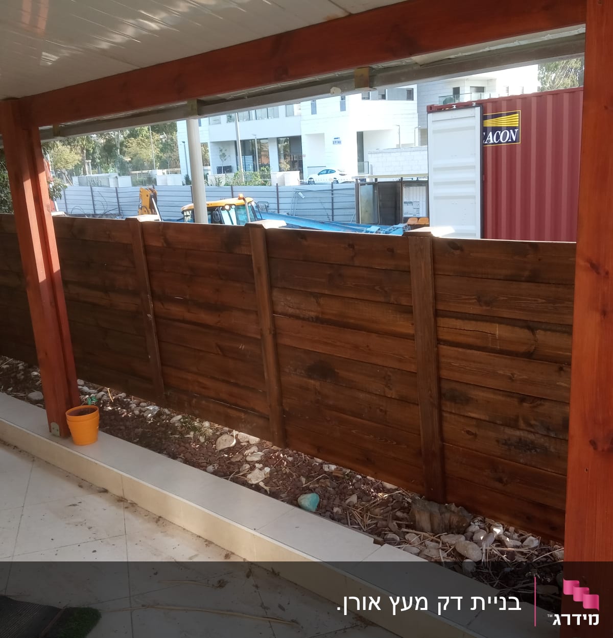 גדר עץ חומה עם עמודי תמיכה אדומים